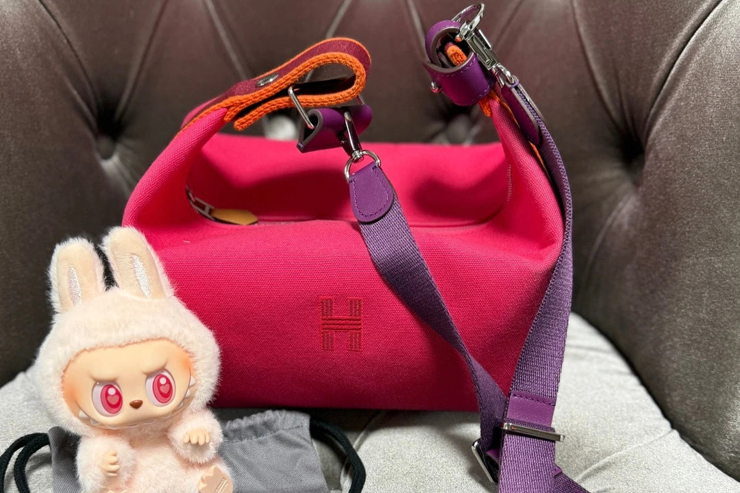 ソファに置いたピンクのバッグと、パープルのストラップ